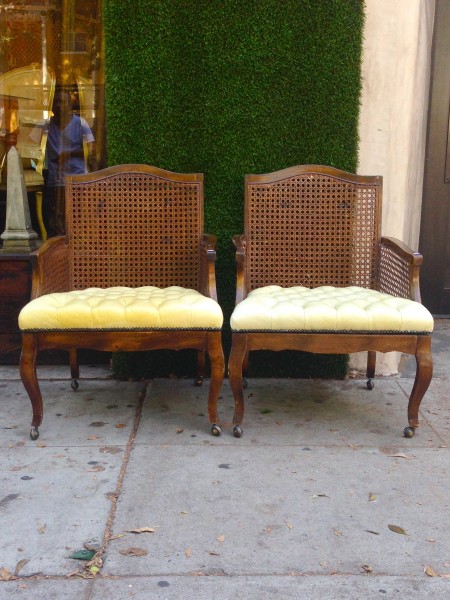 pair of leather tufted lounge chairs on casters