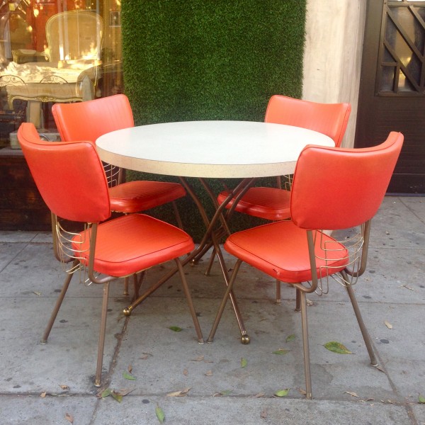retro dining table with 4 orange vinyl chairs