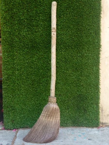 old broom with carved face