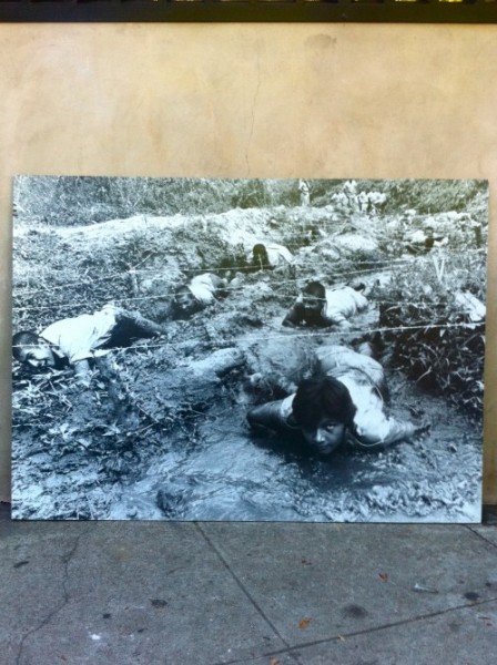 big vintage black & white photo of men crawling on mud